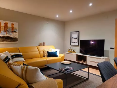 Zona del salón con mueble TV, mesa de centro y sofá